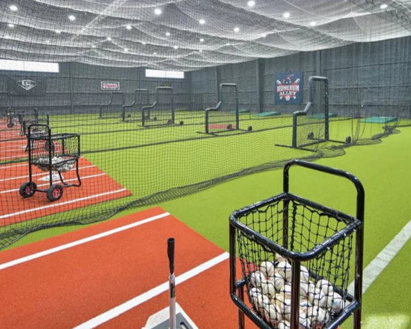 Indoor sports facility with multiple tennis courts and ball machines.